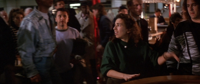 Wide shot frame from Die Hard 2 — standing, room, table
