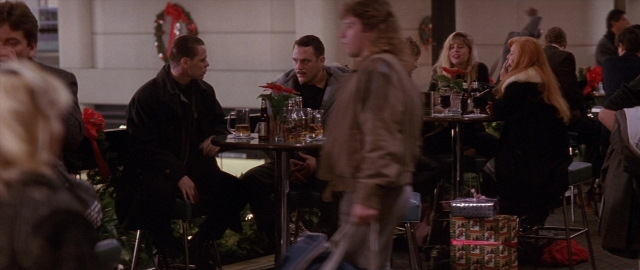 Wide shot frame from Die Hard 2 — sitting, plate, table