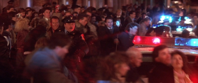 Wide shot frame from Die Hard 2 — walking, street, hat