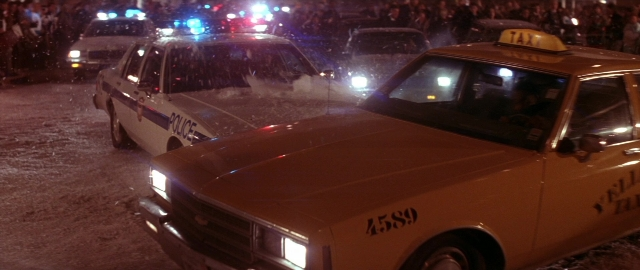 Wide shot frame from Die Hard 2 — standing, street, car