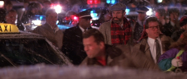Wide shot frame from Die Hard 2 — standing, street, hand