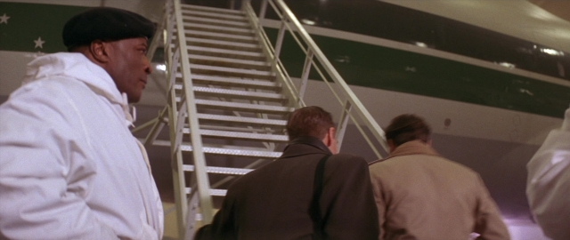 Frame from Die Hard 2 — standing, face, bag
