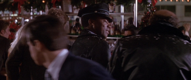 Wide shot frame from Die Hard 2 — standing, table, dialogue