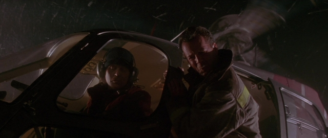 Wide shot frame from Die Hard 2 — standing, door, hat