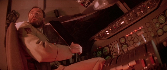 Wide shot frame from Die Hard 2 — sitting, night, beard