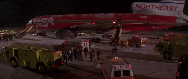 Wide shot frame from Die Hard 2 — fire, night, airplane