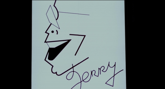 Wide shot frame from The King of Comedy — face, poster, human face