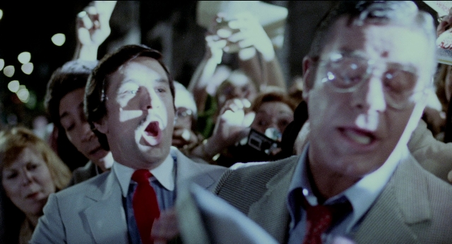 Wide shot frame from The King of Comedy — standing, dialogue, street