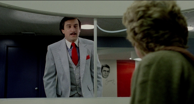 Wide shot frame from The King of Comedy — standing, room, door