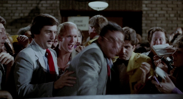 Wide shot frame from The King of Comedy — room, hand, suit