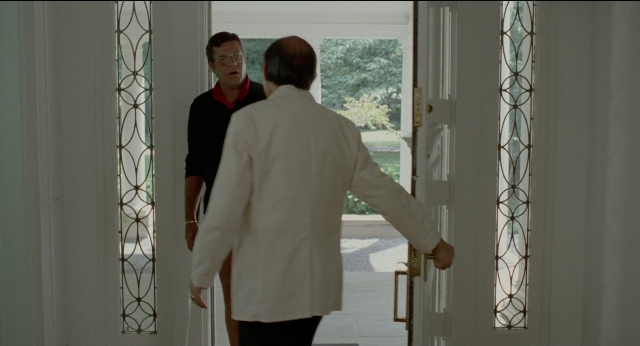 Wide shot frame from The King of Comedy — standing, dialogue, door