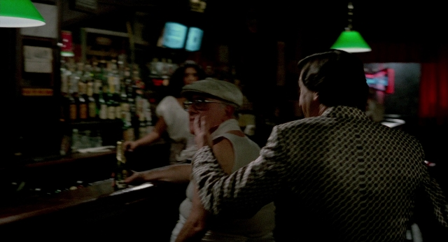 Wide shot frame from The King of Comedy — standing, hat, hand