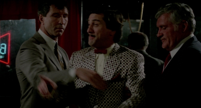 Wide shot frame from The King of Comedy — room, dialogue, suit