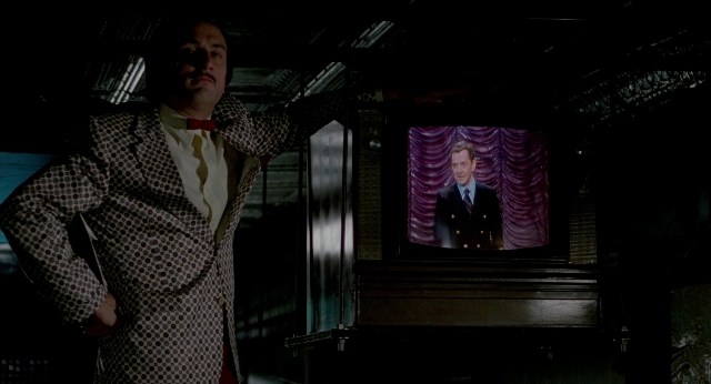 Wide shot frame from The King of Comedy — standing, room, suit