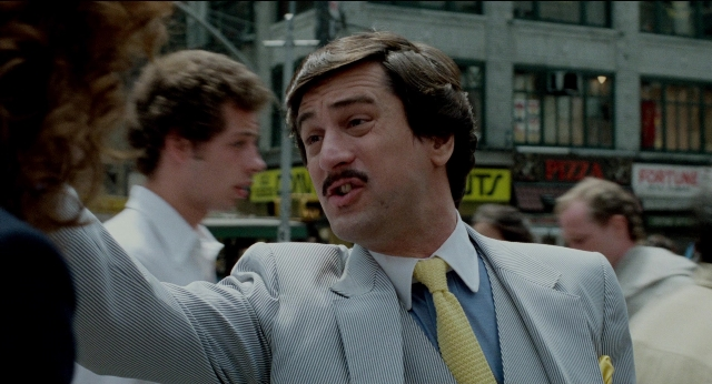 Wide shot frame from The King of Comedy — walking, street, suit