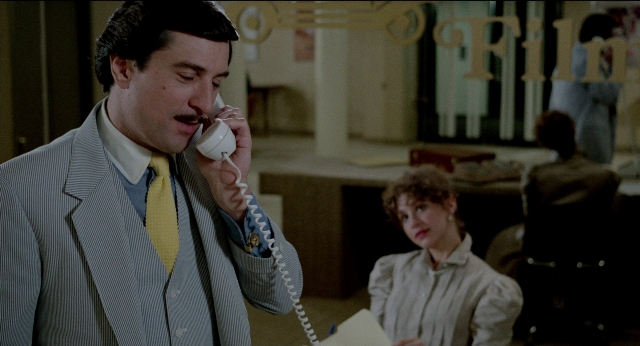 Wide shot frame from The King of Comedy — sitting, standing, room