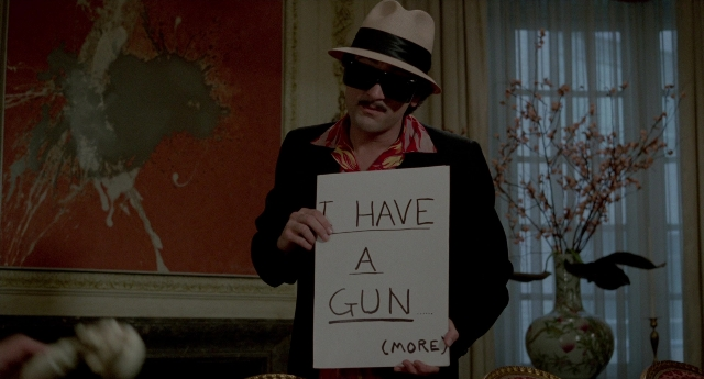 Wide shot frame from The King of Comedy — standing, room, hat
