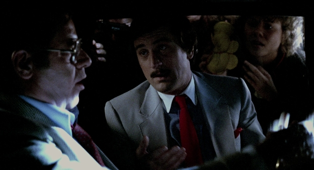 Wide shot frame from The King of Comedy — room, dialogue, suit