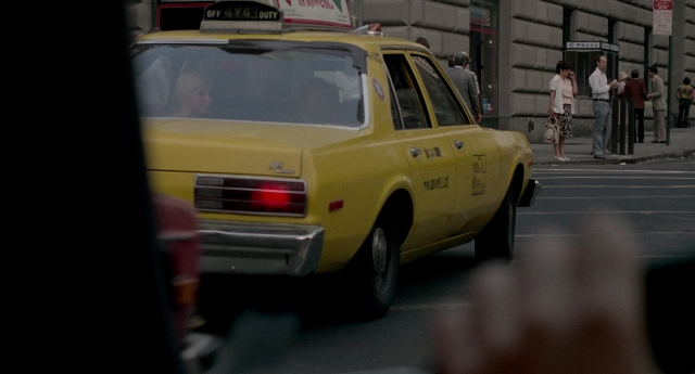 Wide shot frame from The King of Comedy — standing, street, car
