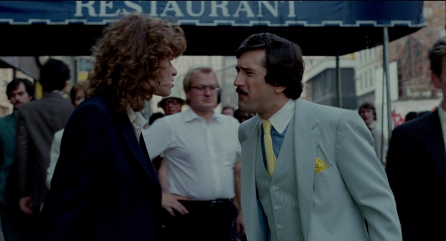 Wide shot frame from The King of Comedy — standing, walking, street