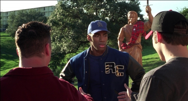 Wide shot frame from The New Guy — standing, dialogue, hat