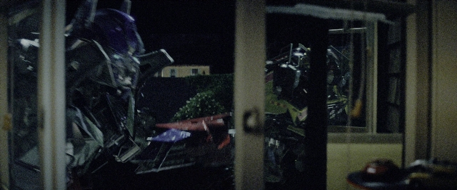 Wide shot frame from Transformers — standing, window