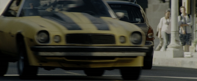 Wide shot frame from Transformers — walking, street, car