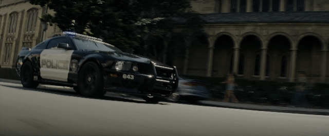 Wide shot frame from Transformers — street, car, wheel