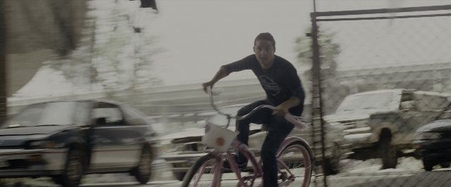 Wide shot frame from Transformers — street, car, bicycle