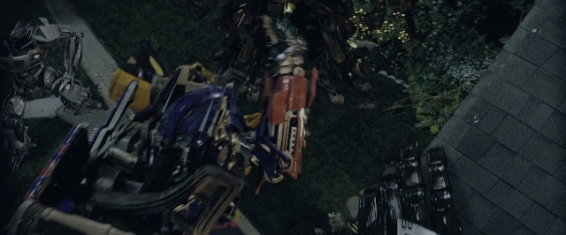 Wide shot frame from Transformers — standing, gun, land vehicle