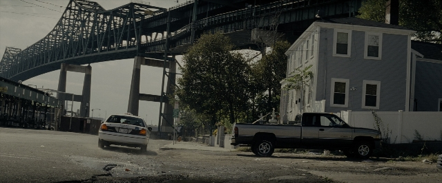 Wide shot frame from Transformers — street, car, house