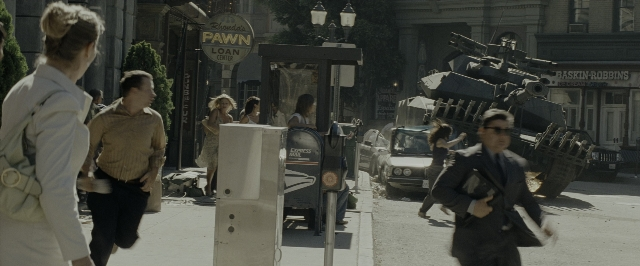 Wide shot frame from Transformers — walking, street, car