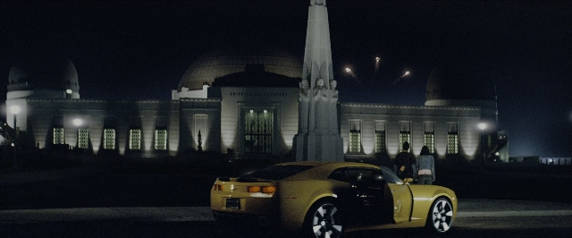 Wide shot frame from Transformers — standing, street, car
