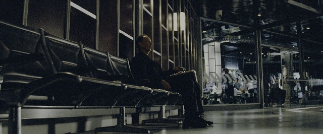 Wide shot frame from Transformers — sitting, walking, suit
