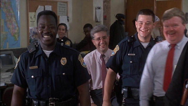 Wide shot frame from Ace Ventura: Pet Detective — standing, room, uniform