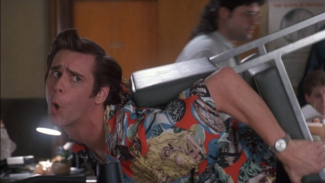 Medium shot frame from Ace Ventura: Pet Detective — kitchen, hand, shirt