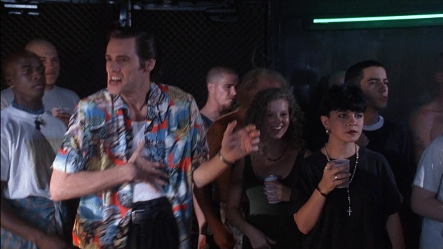 Wide shot frame from Ace Ventura: Pet Detective — standing, room, shirt