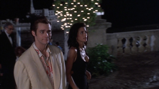 Wide shot frame from Ace Ventura: Pet Detective — walking, suit, night