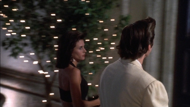 Wide shot frame from Ace Ventura: Pet Detective — standing, room, dress