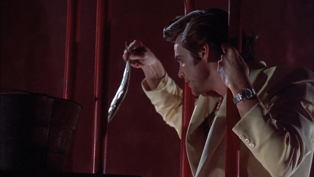 Wide shot frame from Ace Ventura: Pet Detective — standing, hand, suit