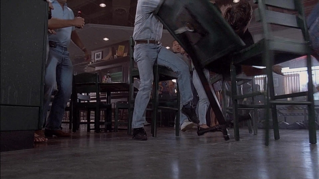 Wide shot frame from Ace Ventura: Pet Detective — sitting, standing, room