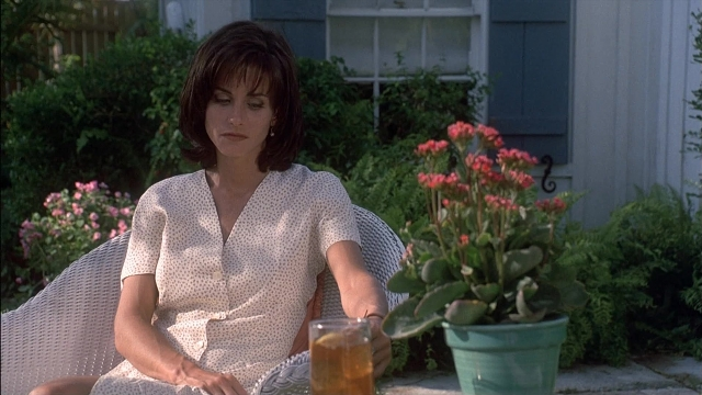 Wide shot frame from Ace Ventura: Pet Detective — sitting, hand, chair