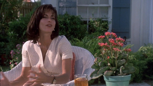 Wide shot frame from Ace Ventura: Pet Detective — sitting, door, chair