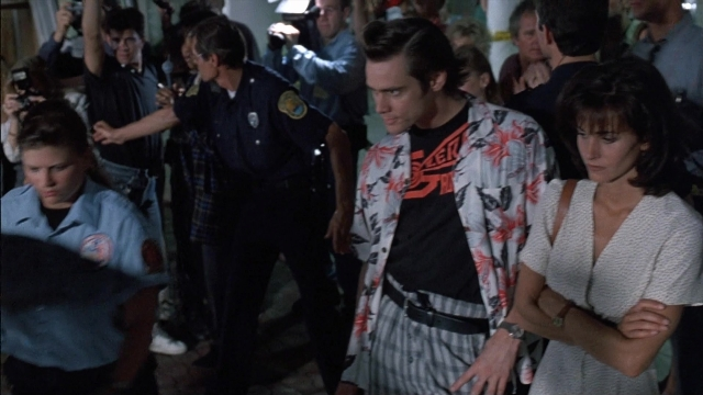 Wide shot frame from Ace Ventura: Pet Detective — standing, room, uniform