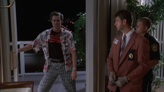 Wide shot frame from Ace Ventura: Pet Detective — standing, room, night
