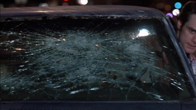 Wide shot frame from Ace Ventura: Pet Detective — street, car, night