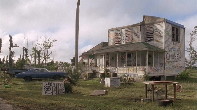 Wide shot frame from Ace Ventura: Pet Detective — table, car, house