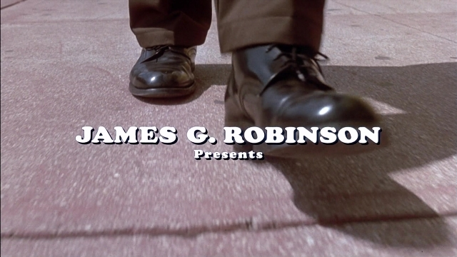 Wide shot frame from Ace Ventura: Pet Detective — standing, street, boot
