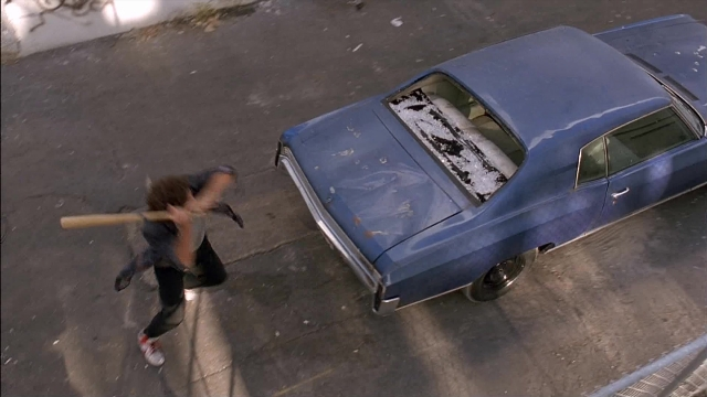 Wide shot frame from Ace Ventura: Pet Detective — street, car, hand