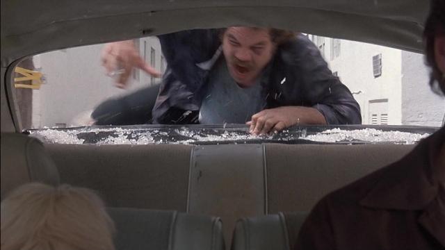 Wide shot frame from Ace Ventura: Pet Detective — car, face, snow